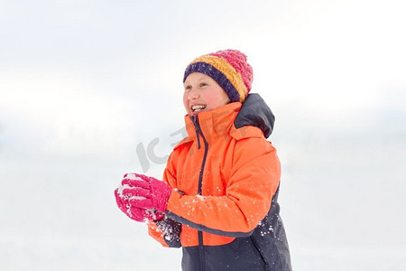 儿童玩雪摄影照片_童年，休闲，季节概念-快乐的女孩在冬天玩雪。快乐的女孩在冬天玩雪