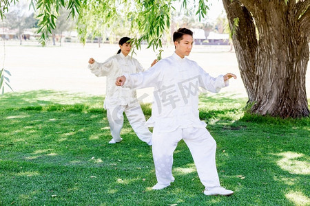 中国人民解放军标志摄影照片_人们在公园里练太极拳。夏天人们在公园里练太极拳