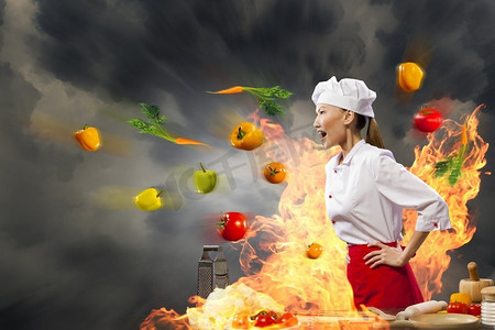 亚洲女厨师在愤怒。愤怒的亚洲女性厨师与flyung蔬菜反对与闪耀效果的颜色背景