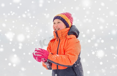 孩子玩雪摄影照片_童年，休闲，季节概念-快乐的女孩在冬天玩雪。快乐的女孩在冬天玩雪