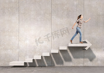 在职业阶梯上往上爬。年轻女商人走上楼梯，象征着成长和进步