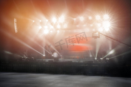 音乐会前的舞台上闪耀着探照灯的光束。前一阶段