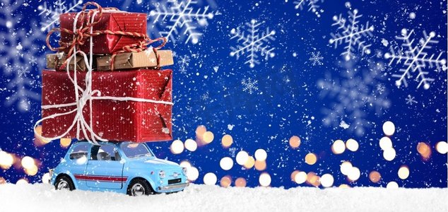带有圣诞礼物的复古玩具车。复古玩具车，在节日蓝色背景下递送圣诞或新年礼物