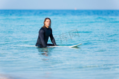 一名年轻的冲浪者在海滩上挥舞着冲浪板。准备好掀起波澜