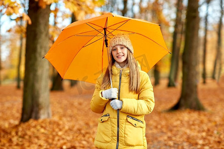 季节和天气概念—愉快的女孩与伞在秋天公园。快乐的女孩与伞在秋天公园