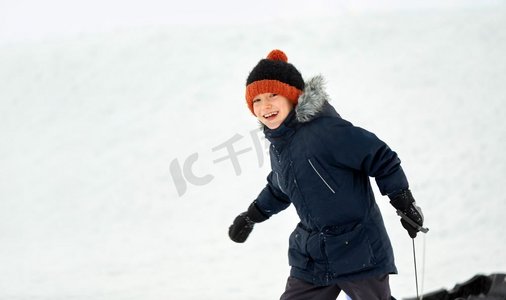 童年，雪橇和季节概念—快乐的小男孩雪橇在冬季户外。快乐的小男孩雪橇在冬天户外