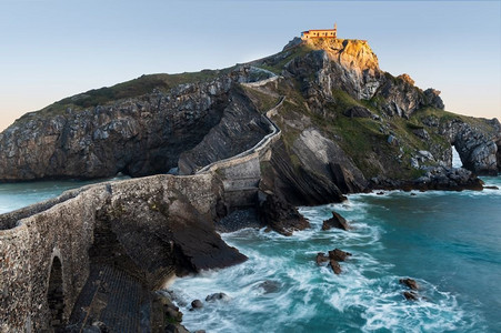 巴斯塔基亚老城摄影照片_圣胡安德Gaztelugatxe，它的中世纪楼梯和桥在日出，西班牙巴斯克地区。圣胡安德天然气工业股份公司