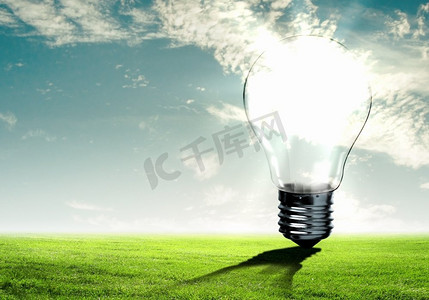 绿色能源背景图摄影照片_灯泡与自然灯泡的图象反对自然背景.生态理念