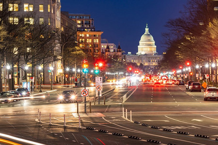 红色日落摄影照片_美国国会大厦在日落沿街道在华盛顿，DC，美国