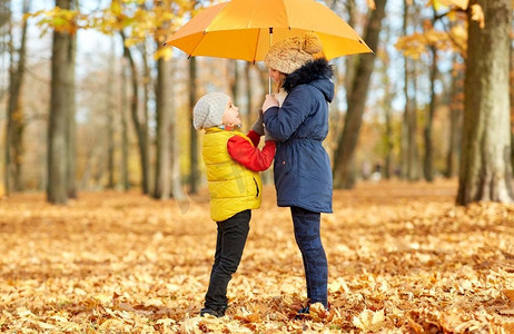 童年、季节和家庭概念-秋天公园里打伞的快乐孩子。秋天公园里打伞的快乐小朋友