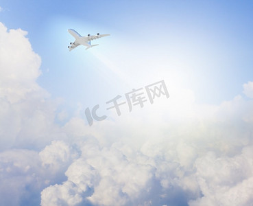 天空中的飞机图像。飞机在晴朗的天空中飞行，背景是太阳