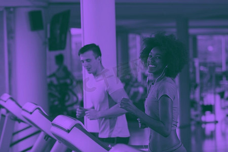 人们在跑步机上做有氧运动。年轻人在现代健身房双音滤色器跑步机上锻炼有氧运动