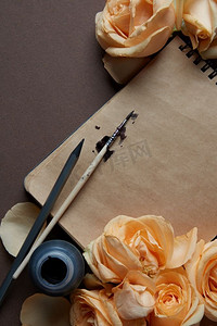 日记或笔记本特写特写镜头由橙色玫瑰覆盖为您的笔记。平铺。情人节的概念。’