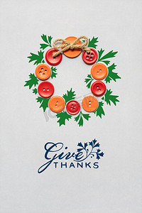 感恩节创意摄影照片_感恩节创意概念照片，由灰色背景上的纽扣制成的花环。