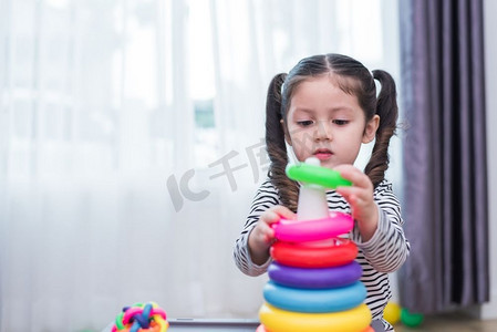 在家里玩小玩具箍的小女孩。教育和幸福生活方式的概念。有趣的学习和儿童发展主题。
