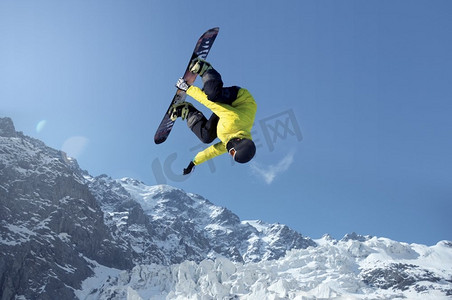 跳高高手摄影照片_单板滑雪运动。单板滑雪运动员在晴朗的蓝天中跳高