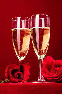 天猫情人节海报摄影照片_香槟和红色心形玫瑰在红色背景下。香槟和红玫瑰