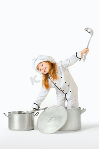 一个漂亮的小女孩装扮成厨房的手，手里拿着锅盖和勺子。