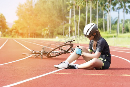 女孩有运动事故受伤在她的膝盖从自行车，运动和事故概念