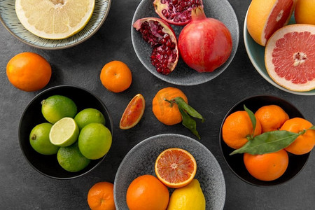 食物，健康饮食和素食概念—关闭柑橘水果在碗在石桌。关闭柑橘在碗水果在石头桌子