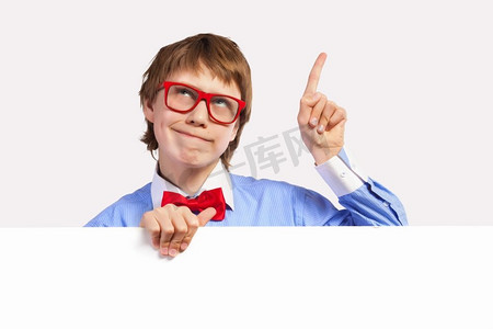 戴红眼镜的男孩拿着白色方块。小男孩若有所思地微笑着拿着白色方块的形象。刊登广告的地点