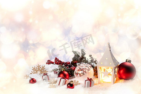 蓝色元宵灯笼摄影照片_圣诞节假期卡与礼物，球，圣诞老人帽子和发光灯笼在雪。圣诞装饰在雪