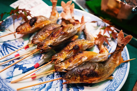 在日本京都的西木市场上，烧烤的鱼作为街头食物。在京都西木市场的街头小吃，烧烤鱼