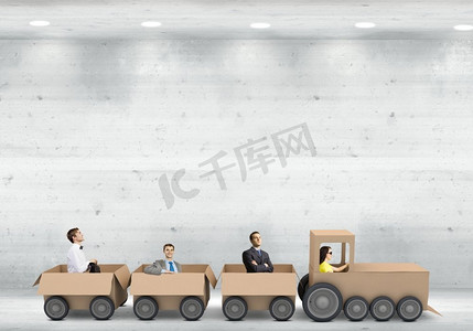 商业中的互动。商务人士乘坐纸箱列车。团队合作理念