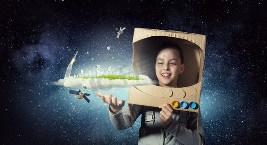 我要探索太空。头戴纸盒头盔的可爱女孩梦想成为宇航员
