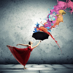 芭蕾舞演员在飞行缎礼服与伞。一个芭蕾舞演员在飞行缎礼服与伞下的油漆