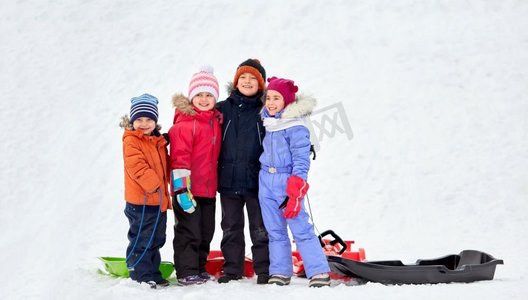 童年，友谊和季节概念—一群快乐的小孩子在冬天拥抱雪橇。快乐的小孩子与雪橇拥抱在冬天