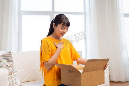 人，送货和运输概念-快乐的亚洲年轻女子在家中拿着包裹盒子。快乐的亚洲年轻女子在家中拿着包裹盒子