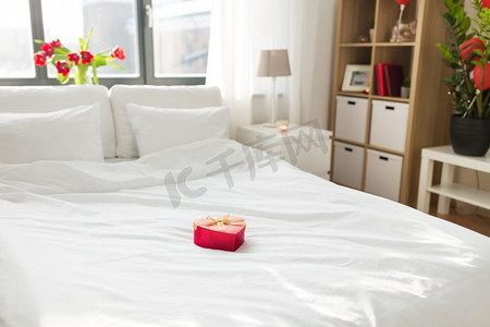 情人节，浪漫的日期和假日概念—礼物在床在家庭卧室的心脏形状。心形礼品盒在床上在家庭卧室 