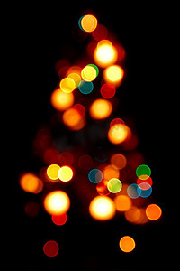 圣诞剪影摄影照片_圣诞树的散景剪影在黑色背景