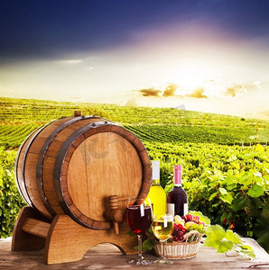 靠近木桶的葡萄和瓶装葡萄酒。桌上放着几杯葡萄酒，酒庄的概念--红白相间。酒庄的概念