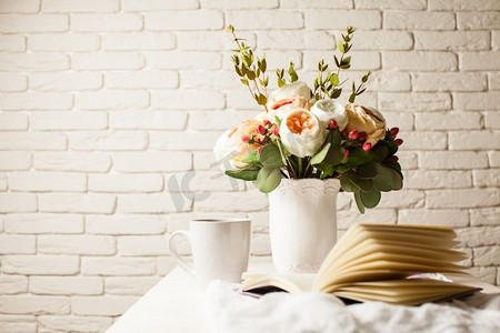 难题摄影照片_桌上放着一杯红茶、一本笔记本和一朵美丽的花。早晨计划一天的灵感。解决难题的启示