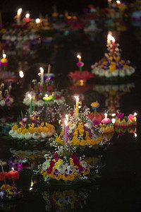 漂浮在水面上摄影照片_在泰国，人们购买鲜花和蜡烛来点燃并漂浮在水面上庆祝Loy Krathong节日。