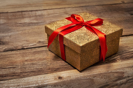 礼物礼物生日圣诞概念-木质背景红色丝带礼品盒。红丝带礼品盒