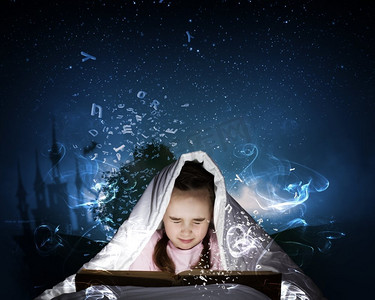 童话书摄影照片_睡前阅读小可爱的女孩与在床上看书在毯子下