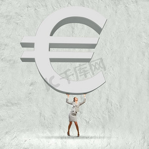 欧元升值。概念形象的女商人解除巨大的欧元标志以上的头部