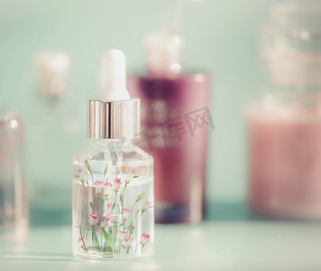 粉色化妆品瓶子摄影照片_瓶子、液体、吸管、小瓶