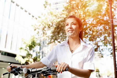 快乐的年轻女自行车手的肖像。快乐的年轻女骑车人在城市里骑行的肖像