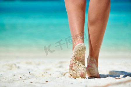 走在热带白色沙滩上的女人。在马尔代夫度暑假。