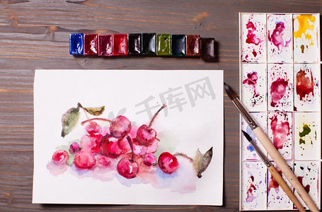 艺术品，在木桌上用绘画工具画樱桃的水彩画。水彩画《樱桃》