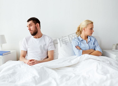 观念分歧摄影照片_人、关系困难和家庭观念-不幸福的夫妻在家中床上发生冲突。不幸福的夫妇在家中床上发生冲突