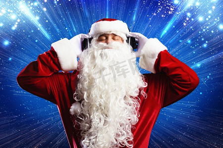 新年快乐。圣诞老人戴着耳机享受音乐