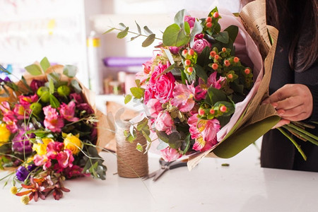 花商制作粉色花束的时尚花束。花商用玫瑰制作花束