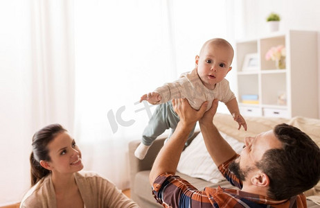 家庭、父母和人的概念-快乐的父母和孩子在家里玩耍。快乐的爸爸妈妈在家陪着宝宝玩耍