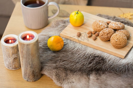 温馨舒适的家居概念--客厅的木桌上有燕麦饼干、柠檬茶和蜡烛。家里的桌子上有饼干、柠檬茶和蜡烛