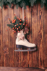 木质墙上挂着圣诞装饰的溜冰鞋。圣诞装饰溜冰鞋
